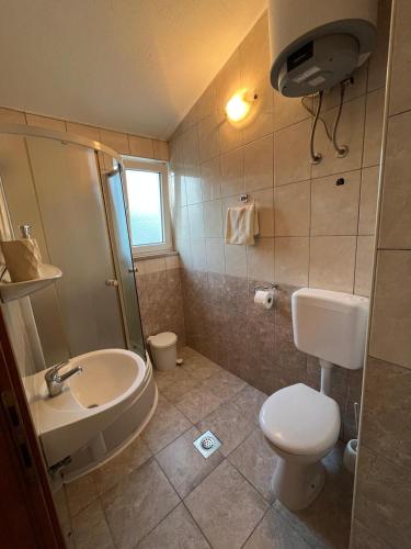 a bathroom with a sink and a toilet and a shower at Rooms Raguž in Neum