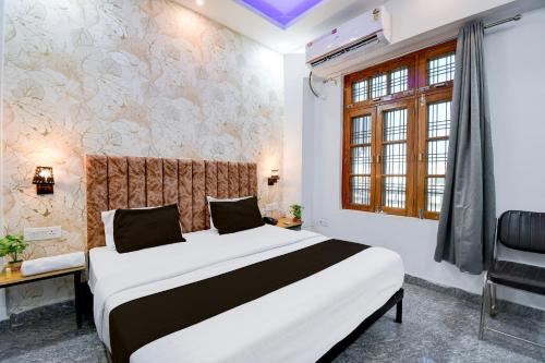 Un dormitorio con una cama grande y una ventana en Hotel O VELMORA HOTEL, en Lucknow