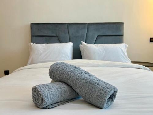 a blanket on a bed with a blue headboard at Casablanca Central Suites - Casa Voyageurs in Casablanca