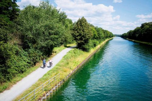 a person riding a bike on a path next to a river at Guest house in Datteln in Datteln