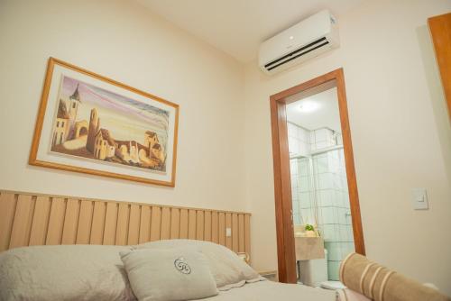 a bedroom with a bed and a picture on the wall at Studio Sudoeste, conforto e segurança(5`Esplanada) in Brasilia
