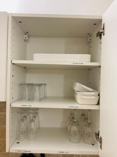 a kitchen with white shelves with glass jars at Appartement in Baie Nettle