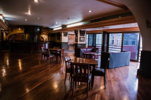 a restaurant with wooden floors and tables and chairs at Hotel Maria Victoria Xalapa in Xalapa