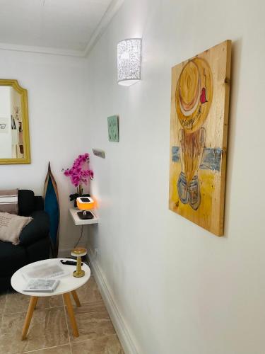 a living room with a table and a painting on the wall at Appartement in Baie Nettle