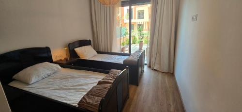 a small room with two beds and a window at Dar Sofia Noria in Marrakech