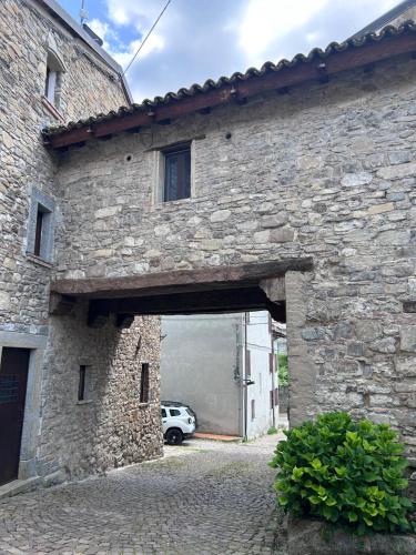 a stone building with a garage with a car in it at Il nido di Matilde in Rossena
