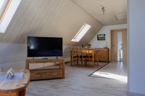 a living room with a flat screen tv and a table at Ferienwohnung Moselurlaub Winningen in Winningen