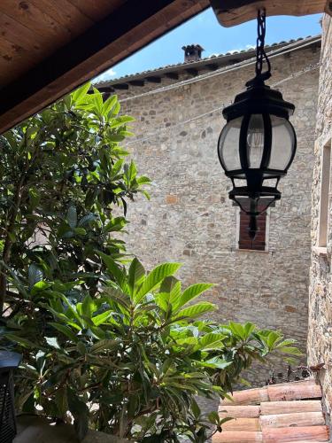 a black light hanging from a brick building with a tree at Il nido di Matilde in Rossena