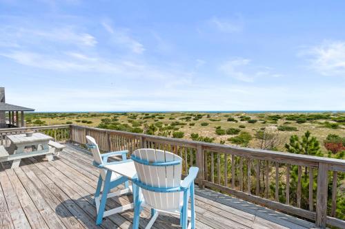 a deck with a blue chair and a table and bench at Sandescape in Salvo