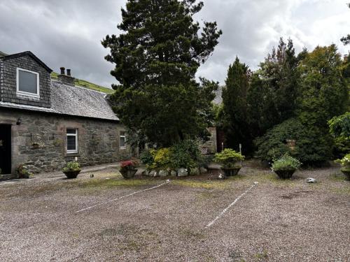 an old stone house with a parking lot at No4 Invereoch in Arrochar