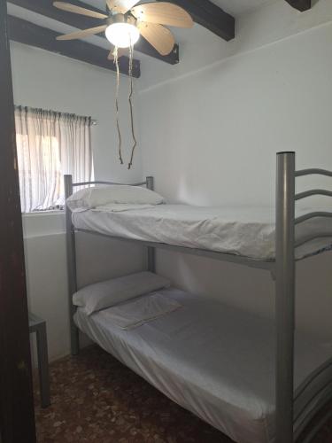 two bunk beds in a room with a ceiling fan at Los Duendes in El Puerto de Santa María