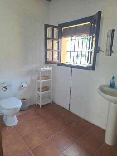a bathroom with a toilet and a sink and a window at Los Duendes in El Puerto de Santa María