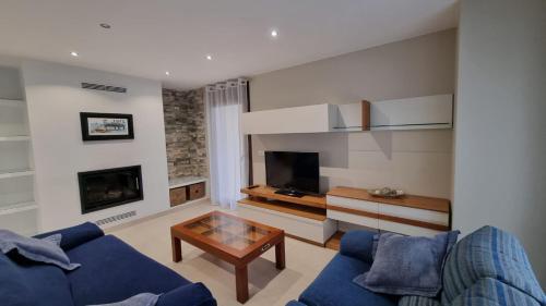 サン・シプリアンにあるA Casa de Chefaの青いソファとテレビのあるリビングルーム