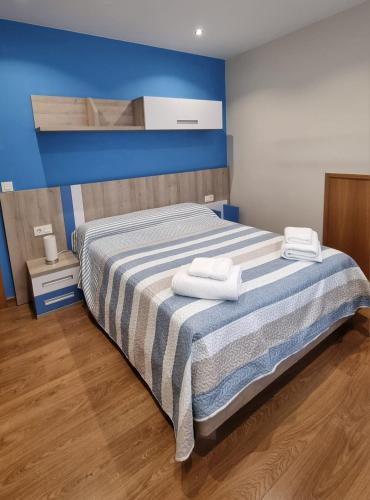 a bedroom with a bed with two towels on it at A Casa de Chefa in San Ciprián