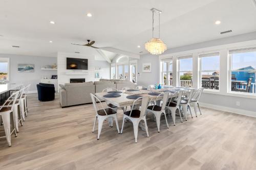 a dining room and living room with a table and chairs at Sandy Cheeks in Kitty Hawk in Kitty Hawk