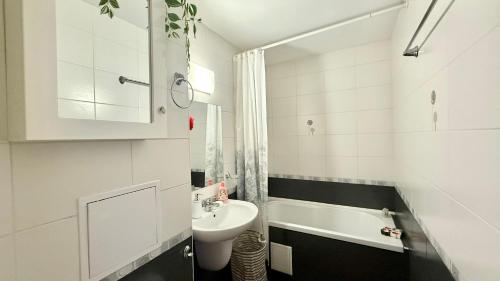 a white bathroom with a sink and a bath tub at Bratanov Garden of Eden in Sveti Vlas
