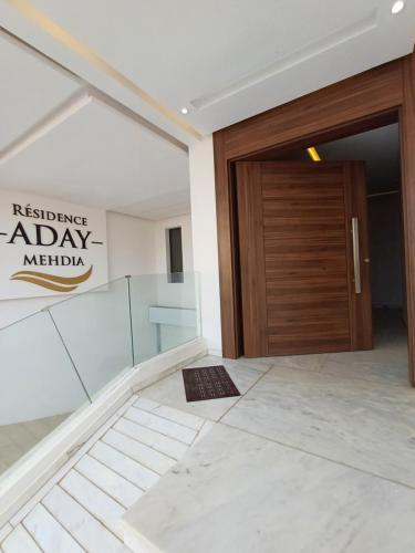 a entrance to a building with a wooden door at Charmant studio familial mehdia plage in Kenitra