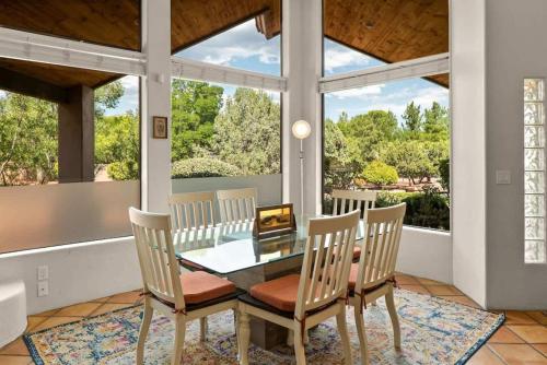a dining room with a glass table and chairs at Sedona Southwest Home with Views Pool and Spa for Family in Sedona