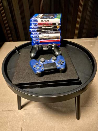 a table with a video game controller and a stack of dvds at אורי בגליל in Qiryat Shemona