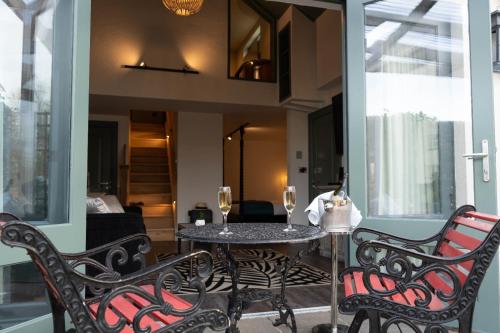 a balcony with a table and chairs and a living room at Bushmills Townhouse in Bushmills