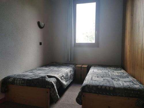 deux lits jumeaux dans une chambre avec fenêtre dans l'établissement Résidence Roche Combe - Le Roche Combe 10 - Agréable studio divisible offrant une magnifique vue sur la vallée MAE-4984, à Valmorel