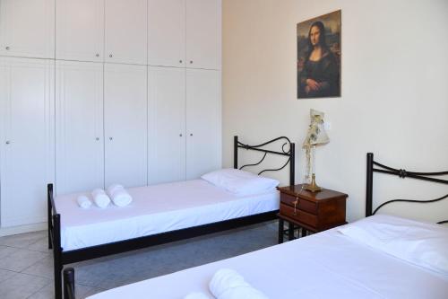 a bedroom with two beds and a dresser in it at 50 Steps From the Sea in Lefkimmi
