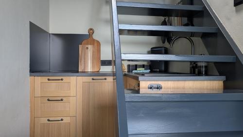 a kitchen with wooden cabinets and a wooden cutting board at CRASH'NSTAY - 't Spoorhuys in Nieuwe Vaart