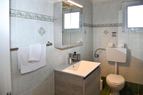 a bathroom with a sink and a toilet and a mirror at 50 Steps From the Sea in Lefkimmi