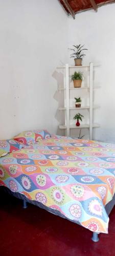 a bed with a colorful comforter in a room at Casa estilo colonial in Pedra de Guaratiba