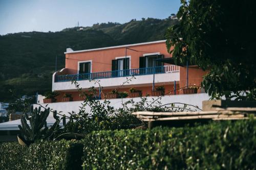 a pink building with a balcony on a hill at Hotel Villa Maria in Ischia