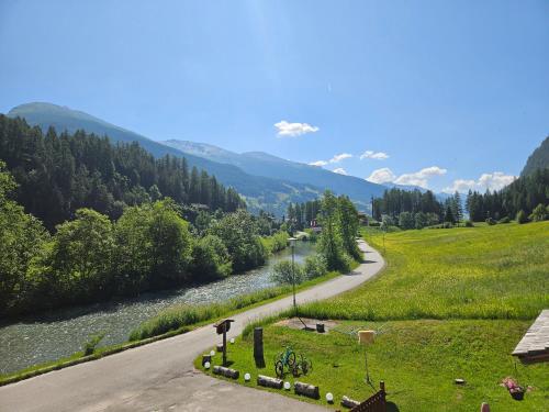 a winding road next to a river in a valley at Landhaus Christoph in Heiligenblut