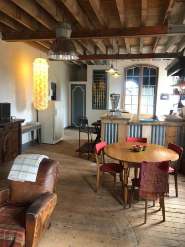 a kitchen and dining room with a table and chairs at Loft industriel aux Grands Moulins de Ruffin in Bréchamps