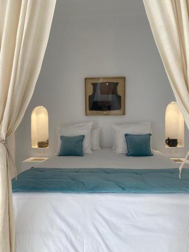 a bedroom with a large bed with blue pillows at Villa Kenzy Djerba in Houmt Souk