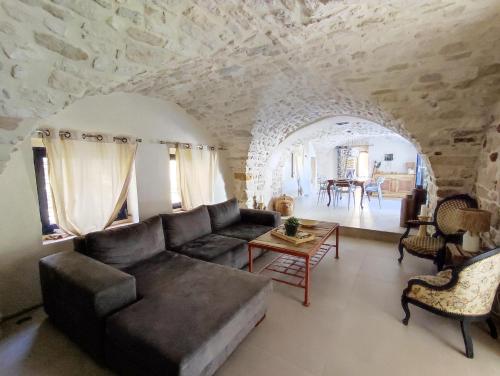 a living room with a couch and a table at Charmante maison provençale proche d'Uzès in Garrigues-et-Sainte-Eulalie
