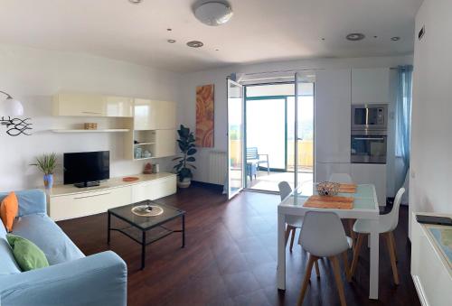 チェッレ・リーグレにあるTraMonti e Mare, vista mare giardino, la casa che in ogni stagione si trasforma!, ideale famiglie con bambiniの青いソファとテーブルのあるリビングルーム