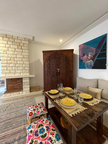 Oulad AkkouにあるThe Painter Houseのダイニングルーム(木製テーブル、皿、グラス付)