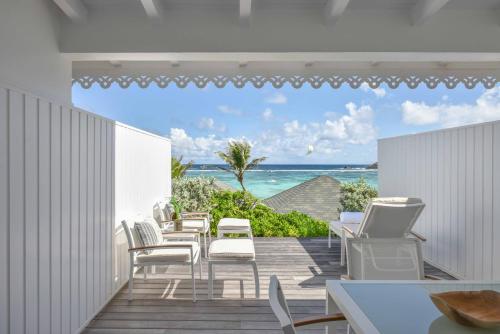 a balcony with chairs and a view of the ocean at Rosewood Le Guanahani St Barth in Marigot