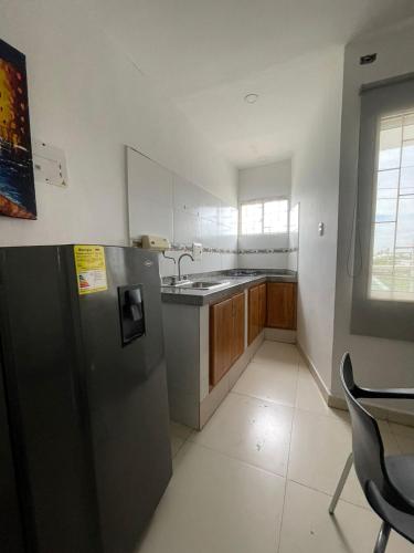 a kitchen with a stainless steel refrigerator and a sink at Apartaestudio Full Central Montería in Montería