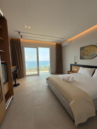 a bedroom with a large bed and a large window at Kalami Rooms Dhermi in Dhërmi