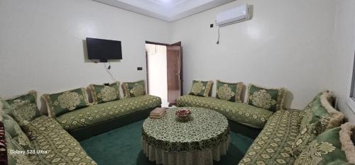 a living room with green couches and a table at Ouled taima boulevard Mohamed 5 in Oulad Teima