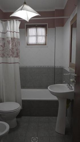 a bathroom with a toilet and a sink and a tub at Cabañas María CAROLINA in San Luis