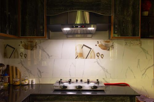 a kitchen with a stove and a microwave at The Mountain Retreat, Muzaffarabad - Families Only in Muzaffarabad