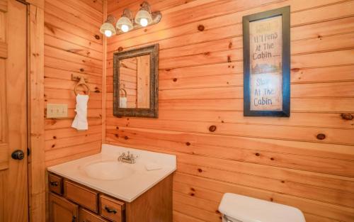 a bathroom with a sink and a mirror at Queens Log Cabin in Gatlinburg