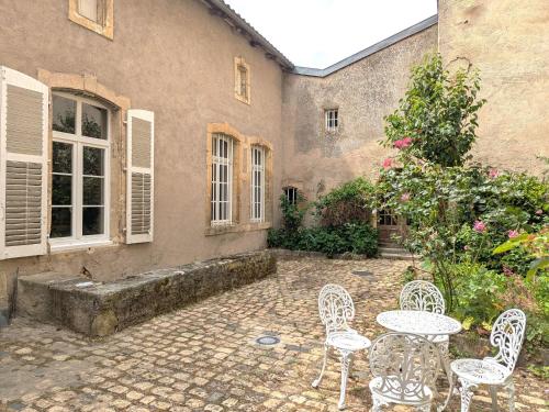 a patio with tables and chairs in front of a building at Gîte élégant au Château d'Euvezin avec jardin et parking privatif - FR-1-584-383 in Euvezin