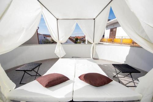 un letto bianco con 2 cuscini su un balcone di Villa Sara a Vodice