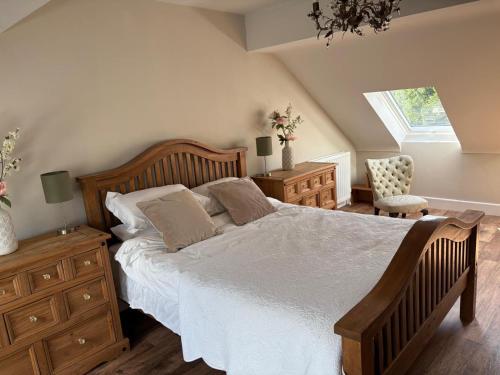 een slaapkamer met een bed, een ladekast en een raam bij Cuilcagh Luxury Apartment in Enniskillen