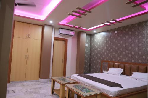 a bedroom with a bed with a pink lighting at The ARL Hotels & Banquets in Patna