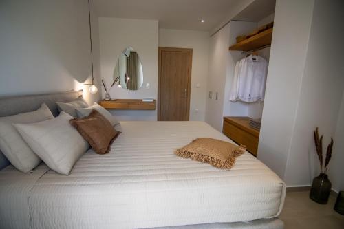 a bedroom with a large white bed with pillows at Aigis Skiathos in Skiathos Town