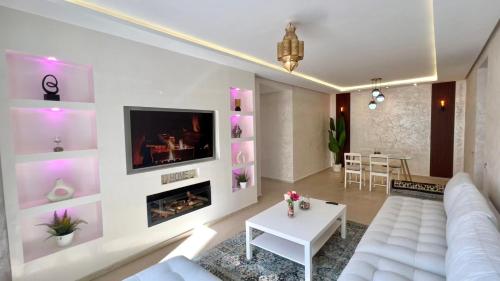 ein Wohnzimmer mit einer weißen Couch und einem Kamin in der Unterkunft N9 Appartement pied sur mer, La Corniche Rabat in Rabat