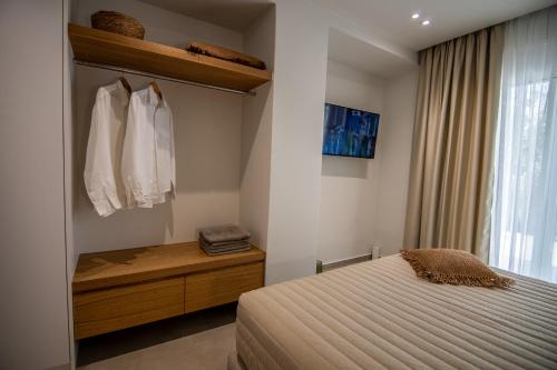 a bedroom with a bed and a dresser and a window at Aigis Skiathos in Skiathos Town